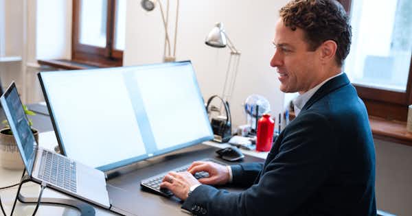 Man in an office setting typing on a computer.