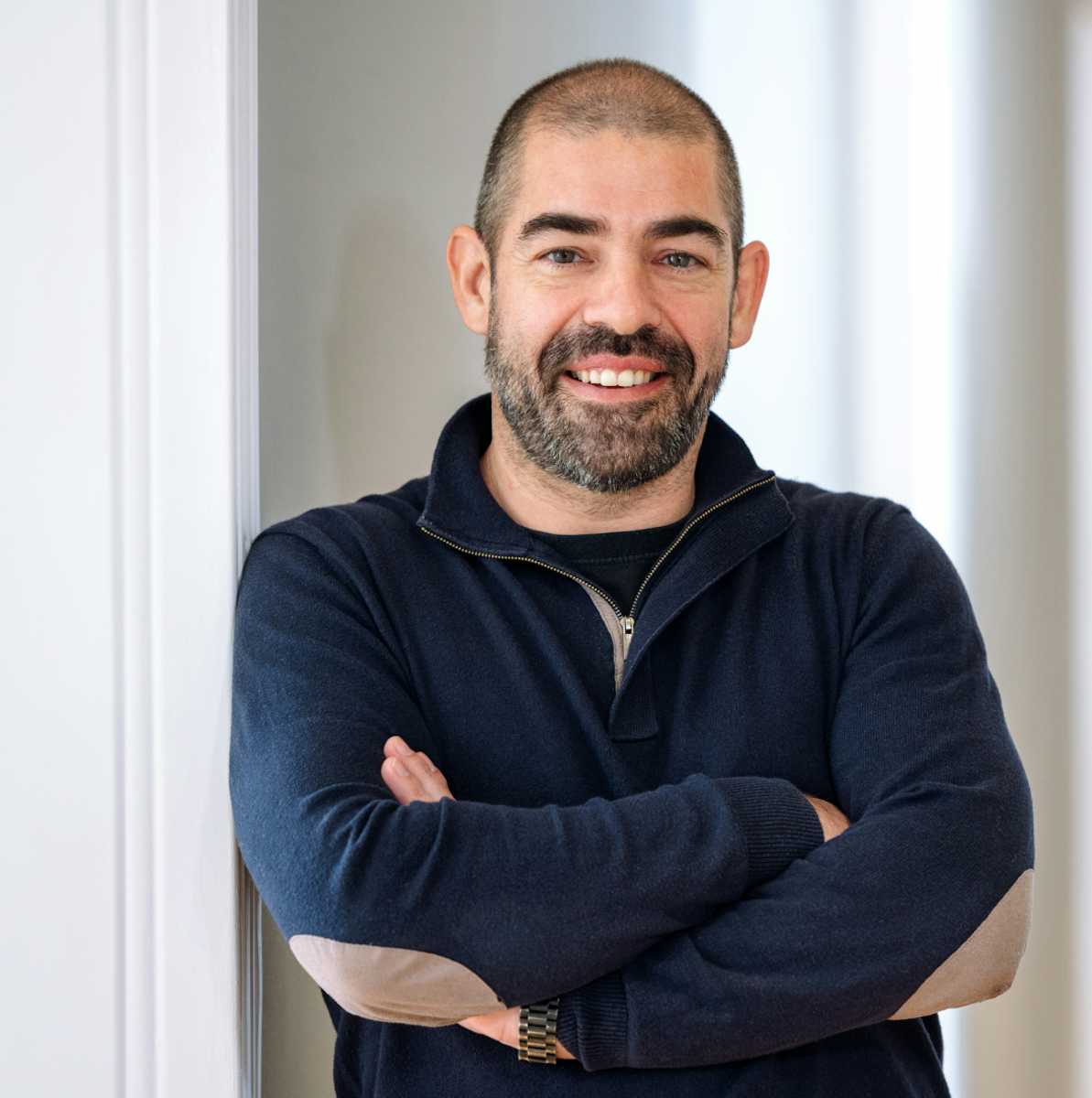 A man standing in a doorway looking at the camera.
