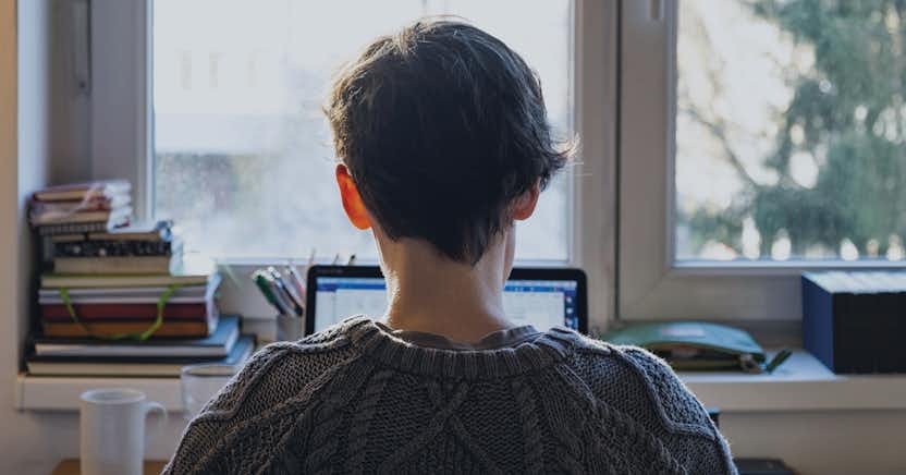 A person looking at a computer screen in a home office setting.