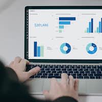 Personne face à un ordinateur avec un dashboard de graphiques