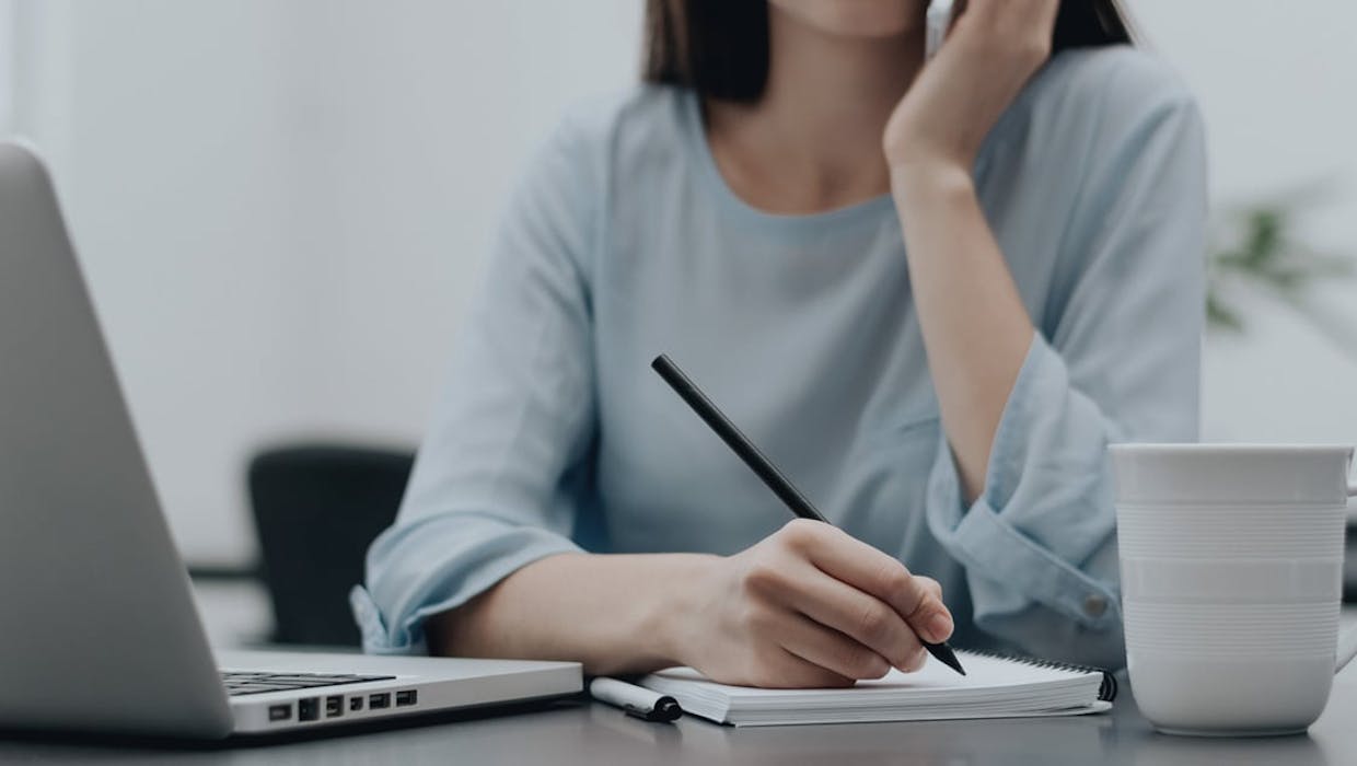 Femme appuyant sa tête sur son menton et regardant un ordinateur.