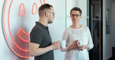 Un homme et une femme discutent ensemble dans le cadre du bureau.