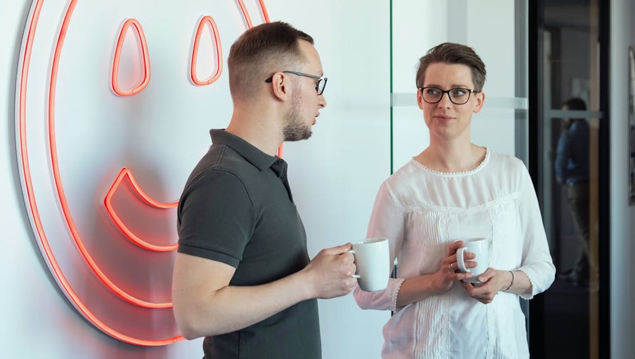 Un homme et une femme discutent ensemble dans le cadre du bureau.
