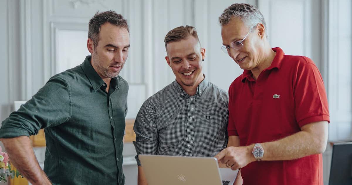 Employés masculins regardant un ordinateur.