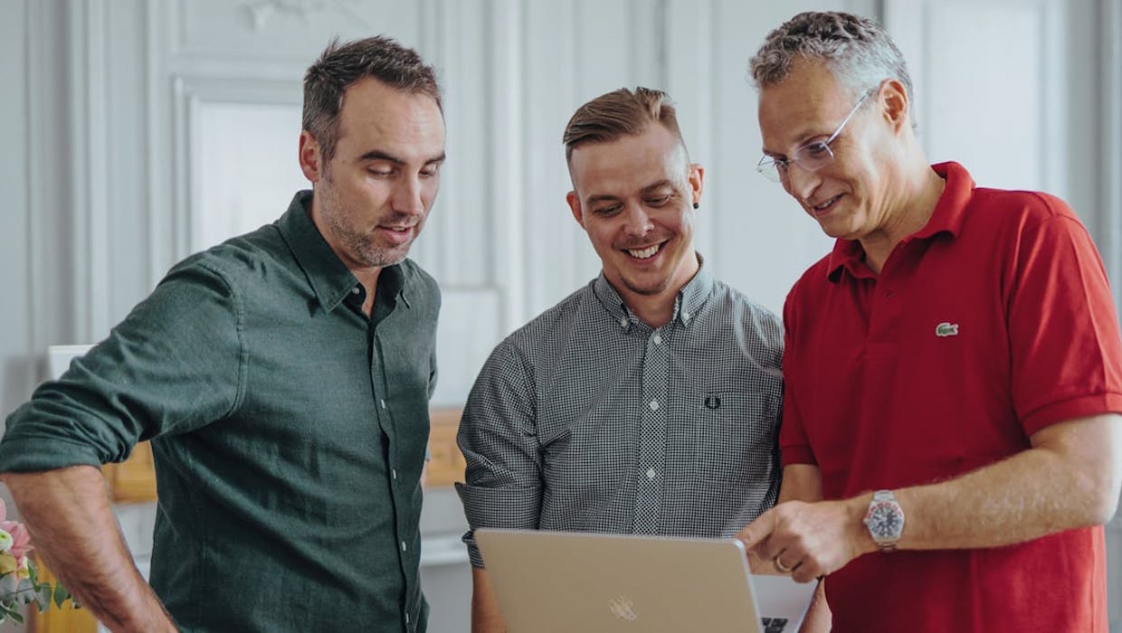 Employés masculins regardant un ordinateur.