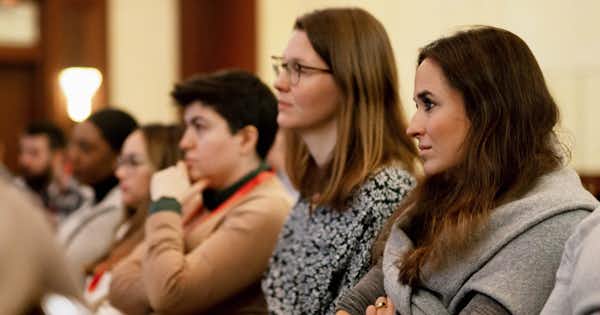 Female and male employees seated in a meeting room