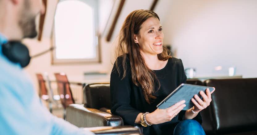 Woman smiling and holding a notebook computer