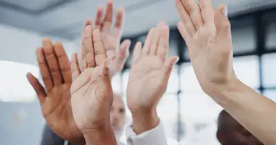 5 mains levées avec différents tons de peau