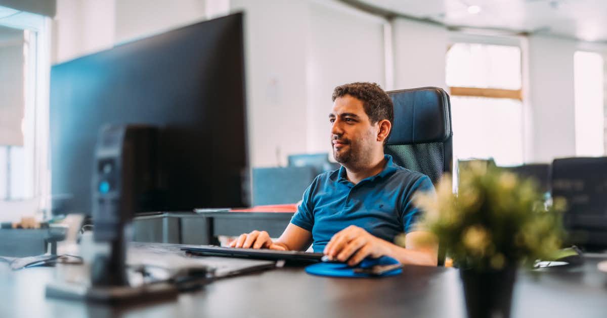 Homme à son ordinateur avec les mains sur le clavier