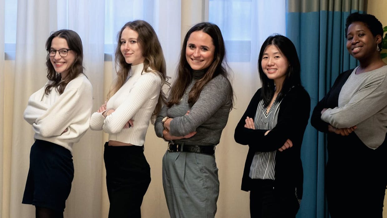 Cinq femmes debout, les bras croisés.