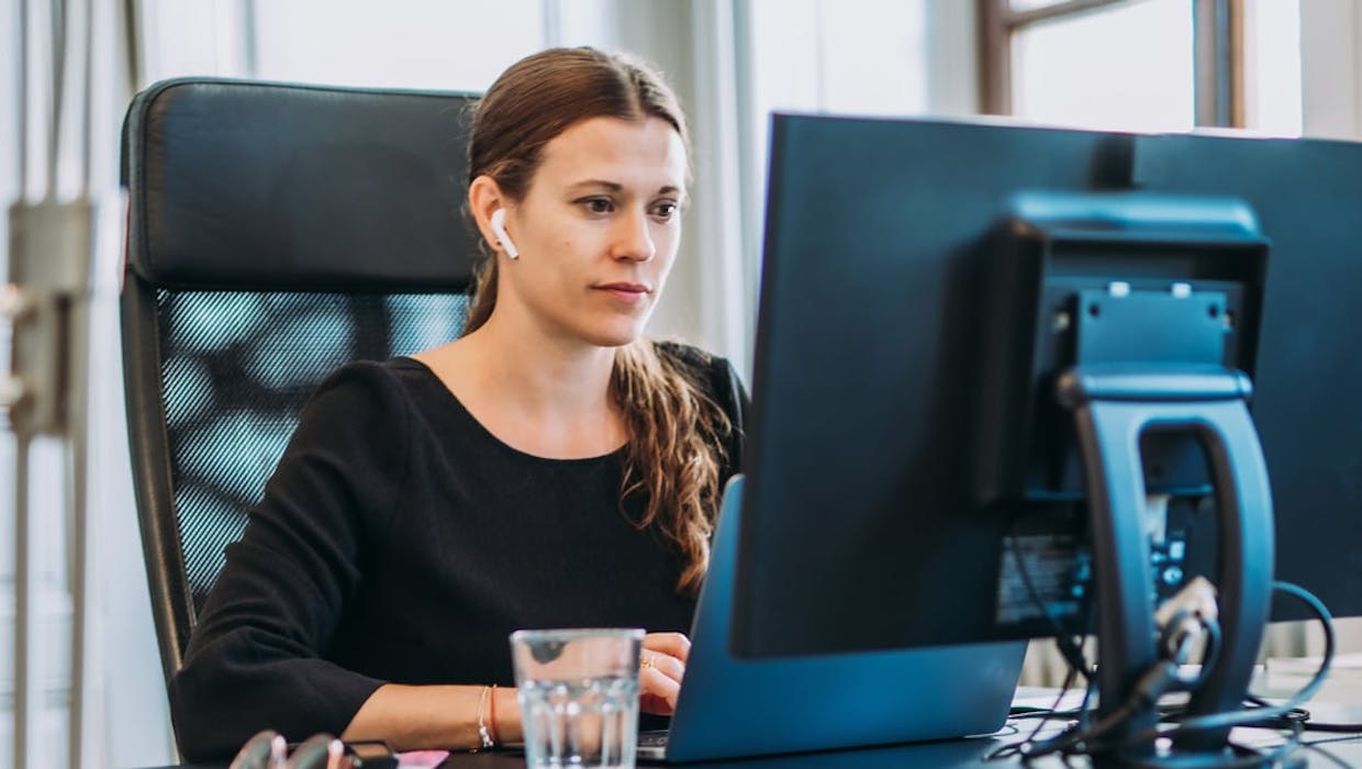 Femme assise en face d'un ordinateur.