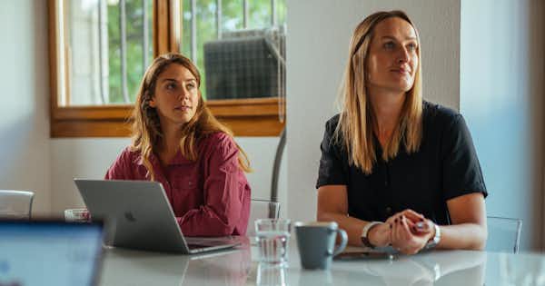 Deux femmes assises à une table avec un ordinateur portable