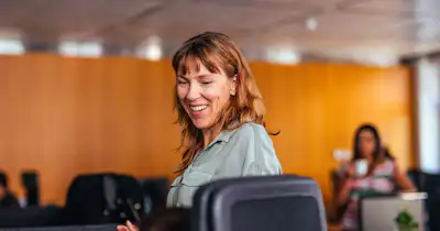 Femme assise sur une chaise, souriante.