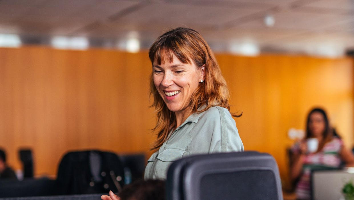 Femme assise sur une chaise, souriante.