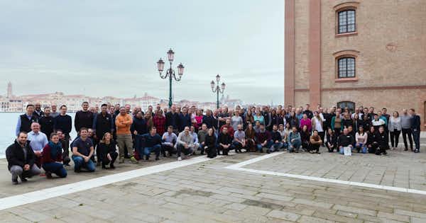 Large group of employees posing for a photo outdoors