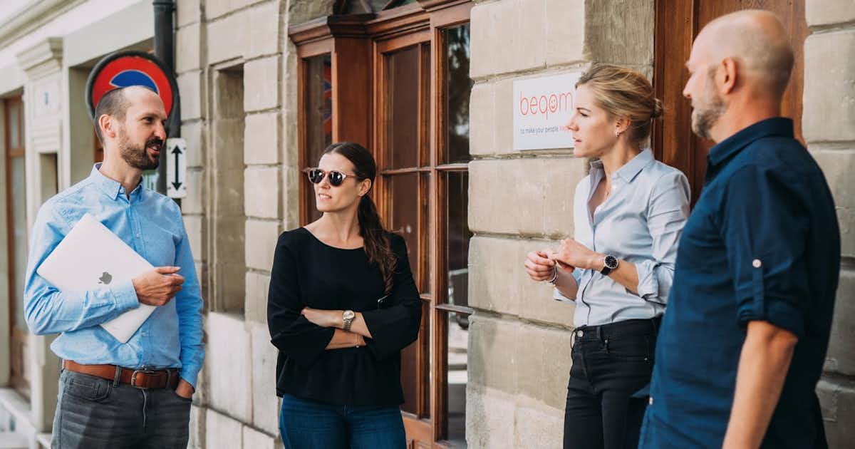 Four employees standing outside the office, talking