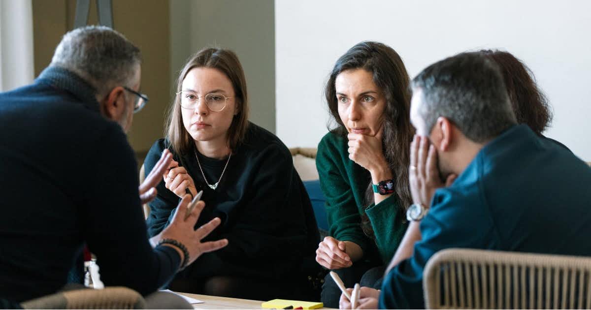 Several team members conferring together around conference table