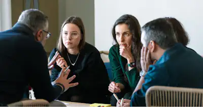 Plusieurs membres de l'équipe se concertent autour d'une table de conférence