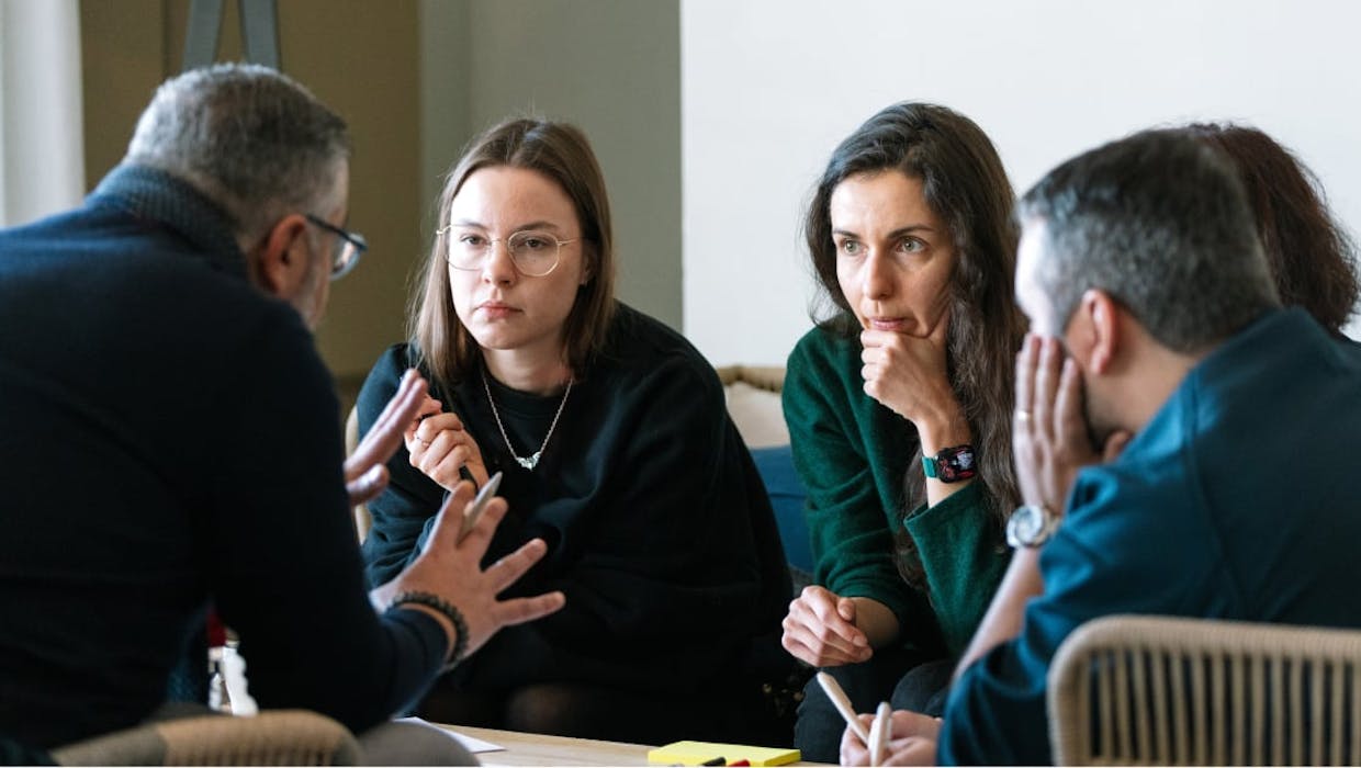 Plusieurs membres de l'équipe se concertent autour d'une table de conférence