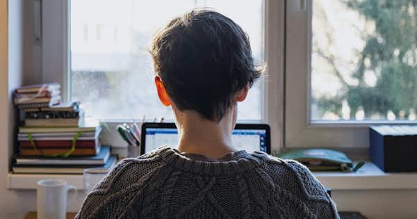 Lone employee at desk looking towards the window