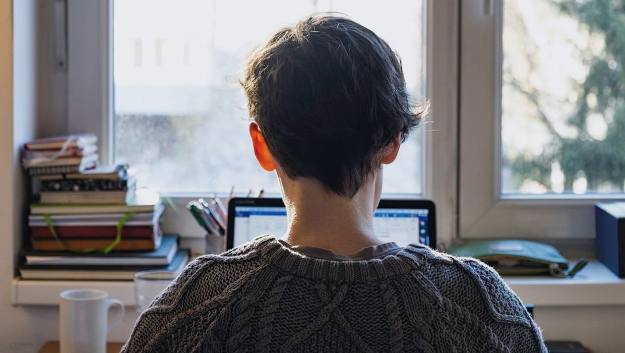 Lone employee at desk looking towards the window