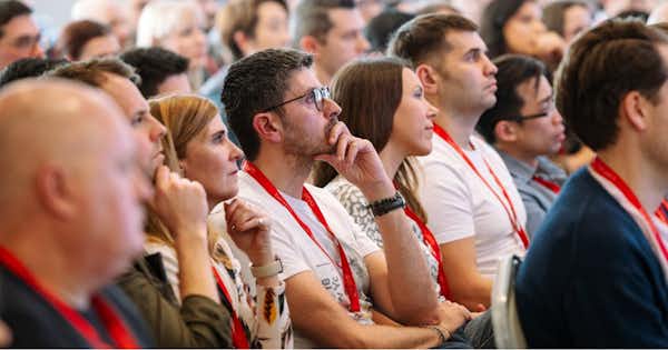 Attendees seated at a conference looking attentive