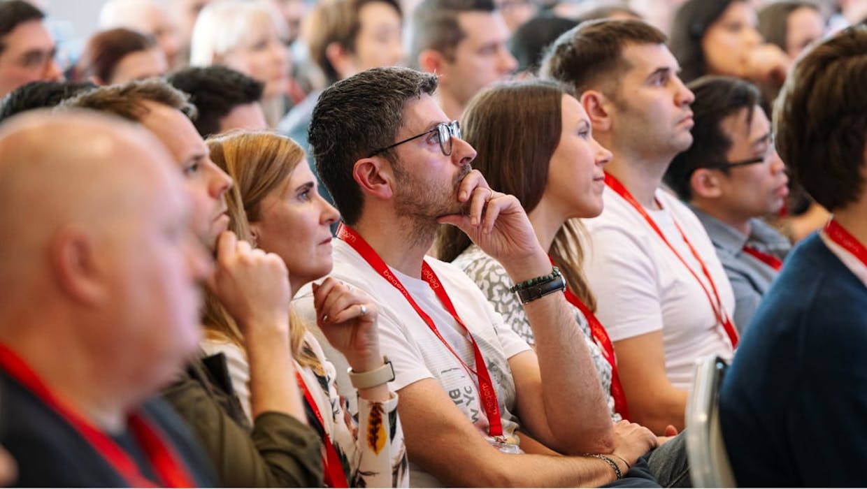 Attendees seated at a conference looking attentive