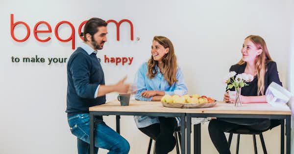 Male and female employees at beqom talking together