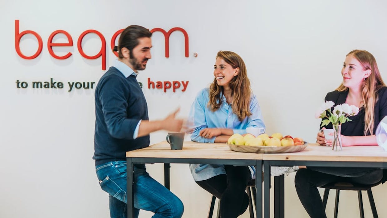 Male and female employees at beqom talking together