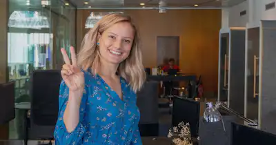 Femme souriante faisant le signe de paix avec deux doigts.