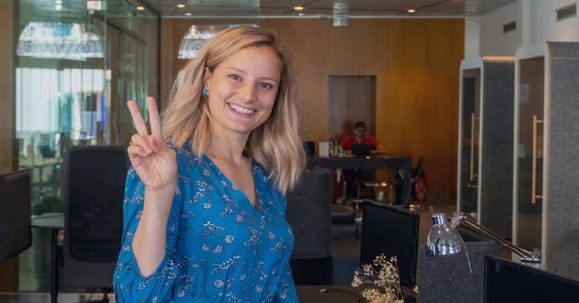 Smiling woman giving a two-finger peace sign