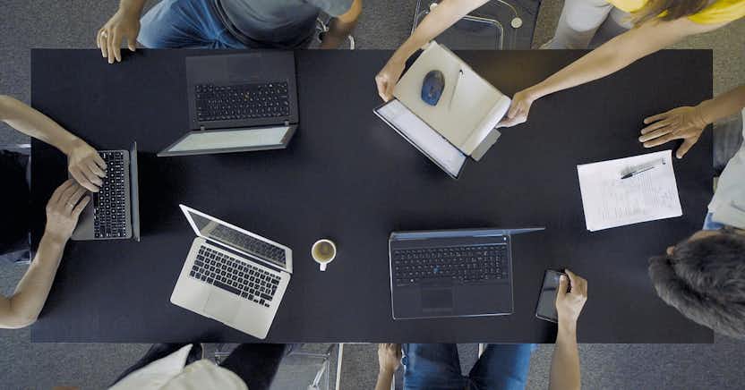 People gathered around a table with laptops