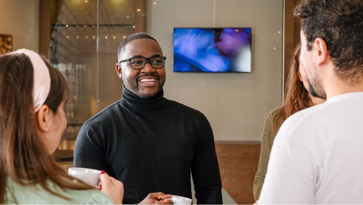 Un homme discutant avec d'autres employés