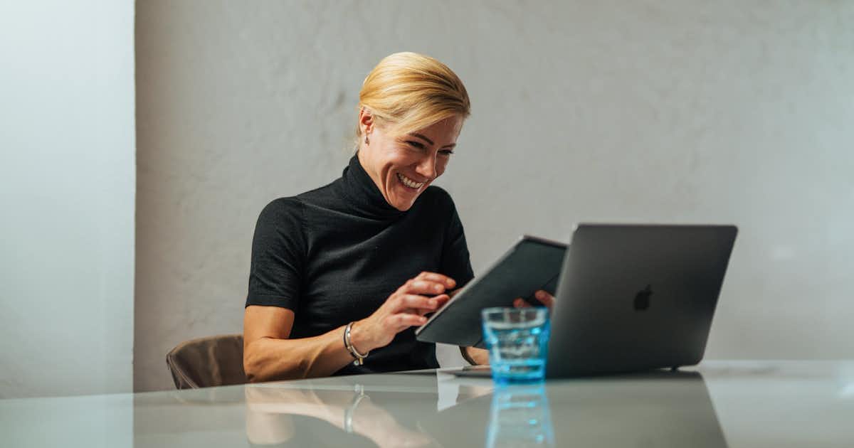 Femme souriante avec son ordinateur portable.
