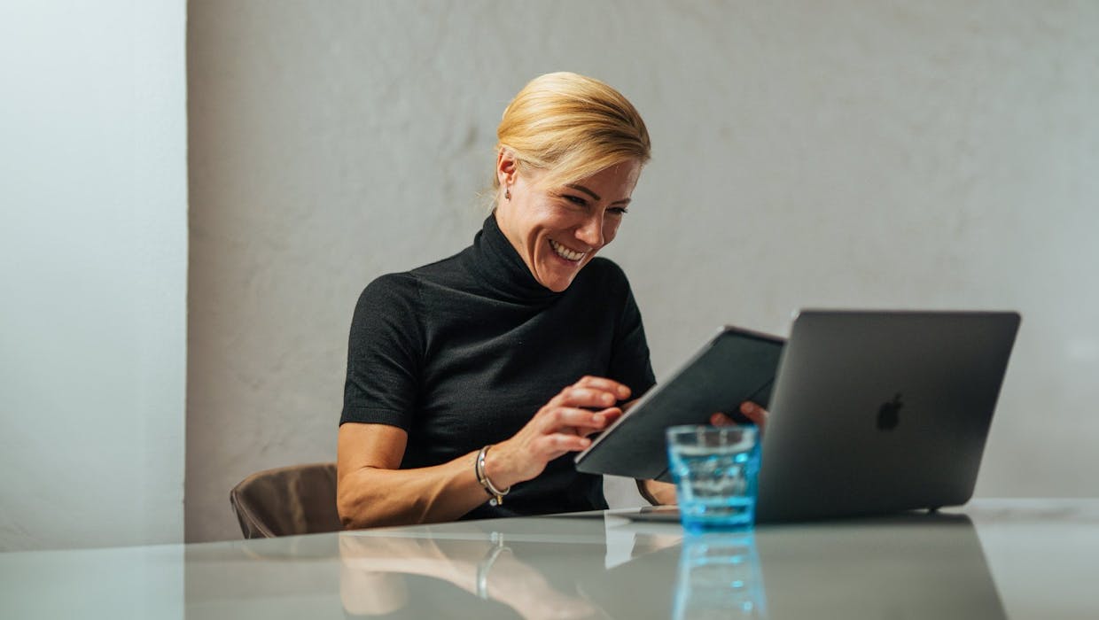 Femme souriante avec son ordinateur portable.