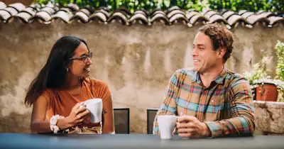 Un homme et une femme assis en train de discuter autour d'un café.