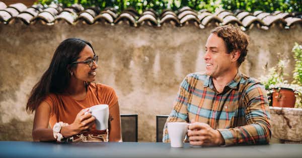 Man and woman seated and talking over coffee