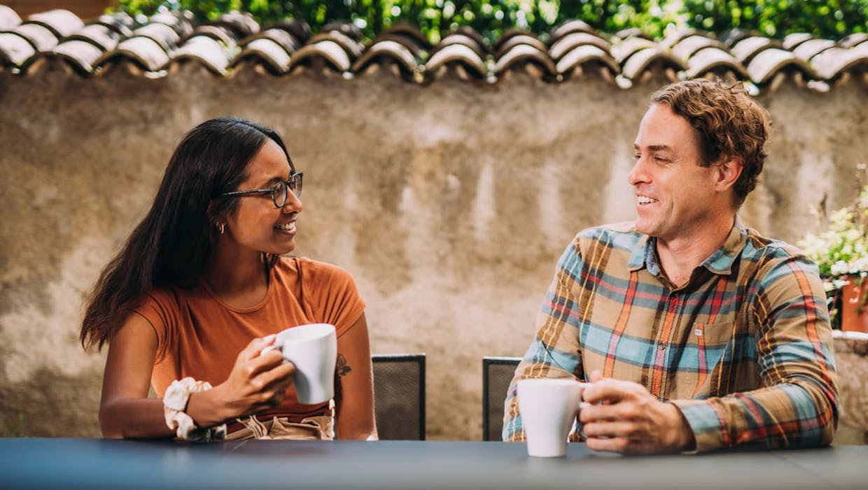 Un homme et une femme assis en train de discuter autour d'un café.
