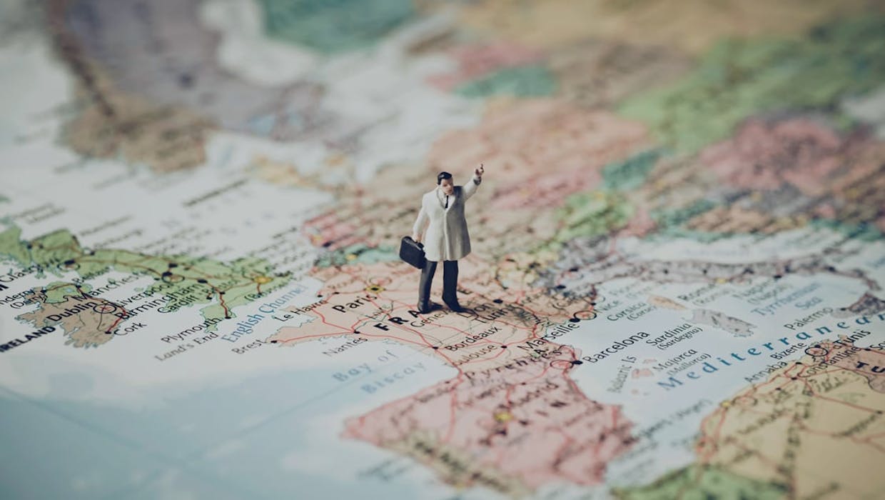 Carte du monde avec un homme debout dessus.