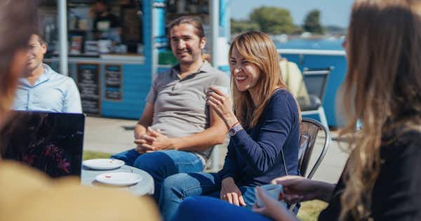 Collègues souriants, réunis autour d'une table.