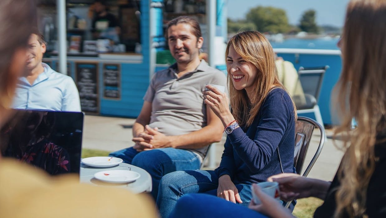 Collègues souriants, réunis autour d'une table.