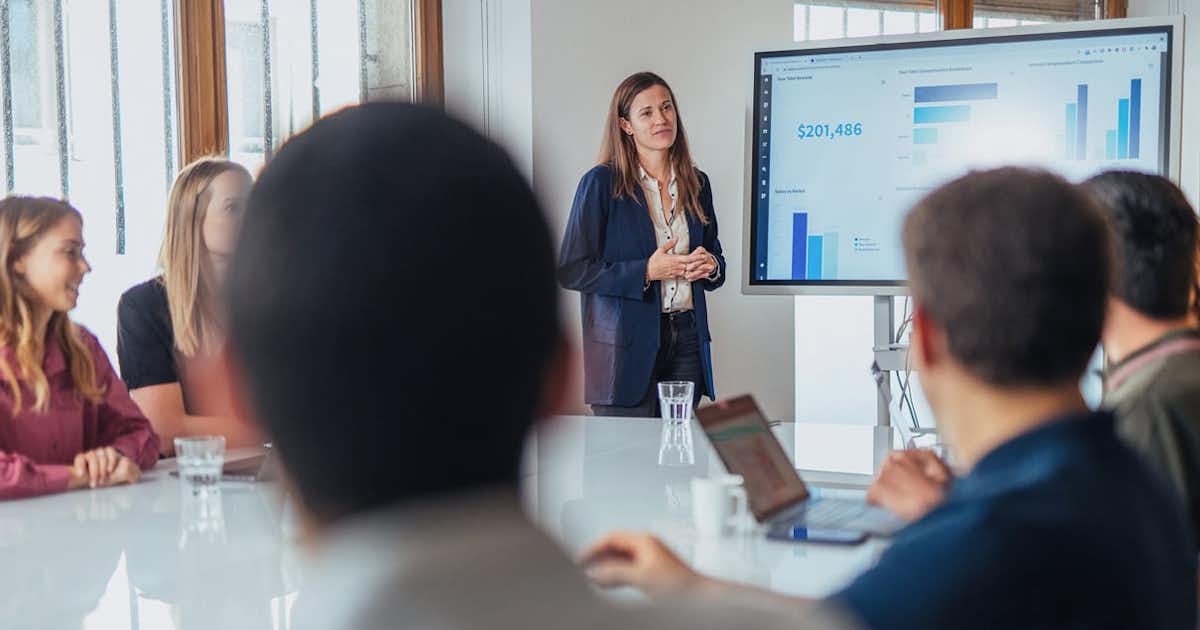 Woman presented a graph to others seated at a table