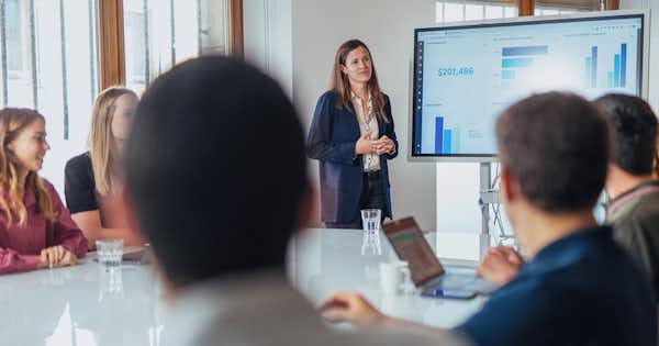 Woman presented a graph to others seated at a table