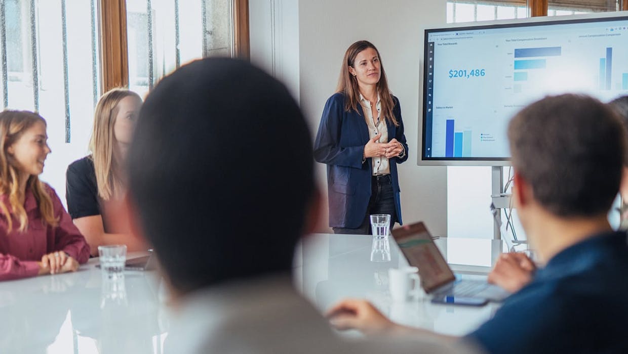 Une femme a présenté un graphique aux autres personnes assises à une table.