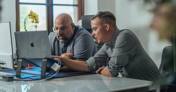 Two employees looking at a computer screen together