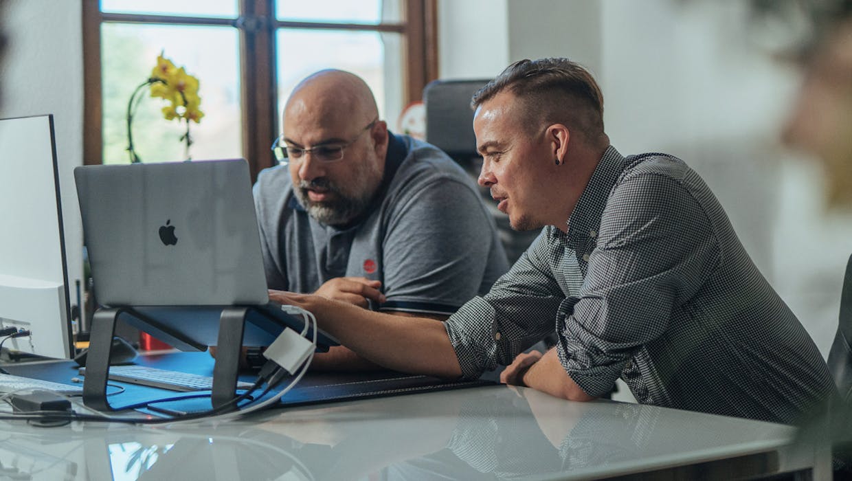 Deux employés regardant ensemble un écran d'ordinateur.