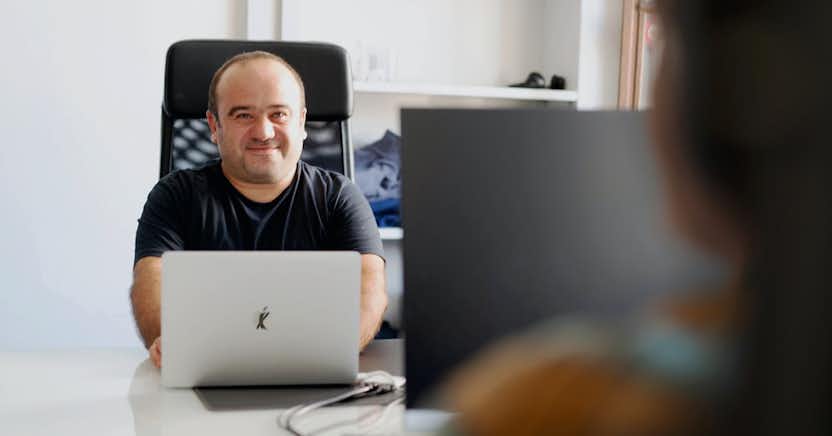 Two employees at desks facing each other.