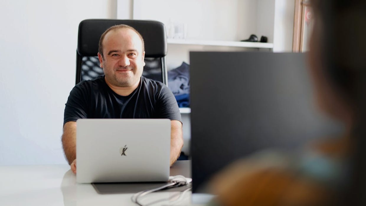 Deux employés assis à des bureaux se faisant face.