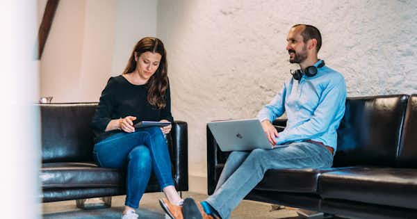 Deux personnes assises sur un canapé.