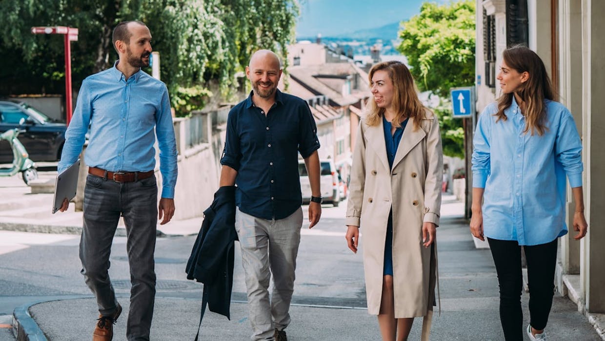 Groupe d'employés, hommes et femmes, marchant dans la rue.